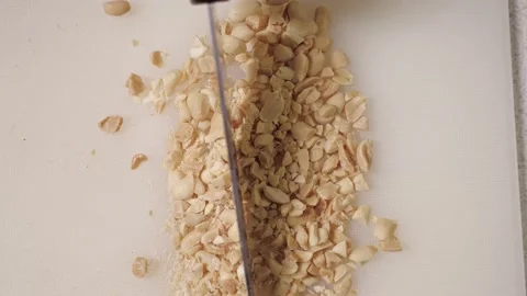 Chop peanuts with a large knife. cooking in the kitchen Stock Footage 169759762