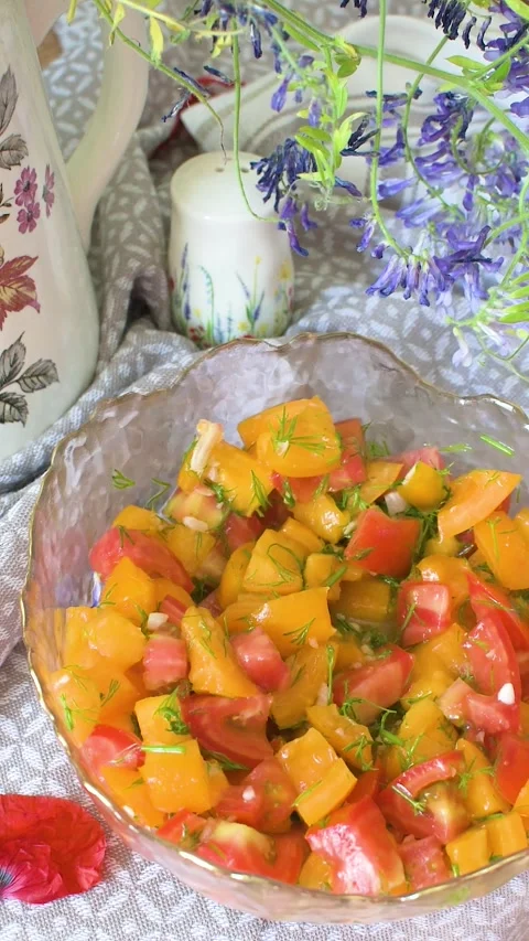 Chop red and yellow tomatoes, mix with young garlic and dill, and serve in .. Stock-Footage 337720249
