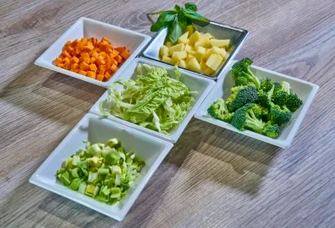 Chopped and ordered vegetables to start cooking Stock Photos
