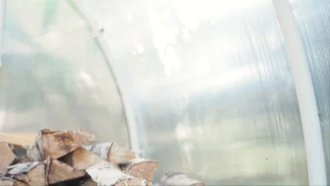 The chopped and sawn trunks of trees is stacked in a large log woodpile in room. Stock Footage 128902765