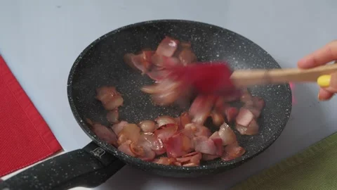 Chopped bacon are fried in a hot frying pan Video stock 131785051