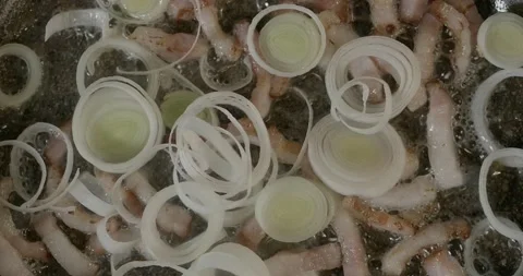 A chopped bacon is fried in a pan with leek, cream and seasoning. Preparing a Vidéo 221761263