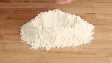 Chopped butter being placed on a pile of flour Stock Footage 24669619