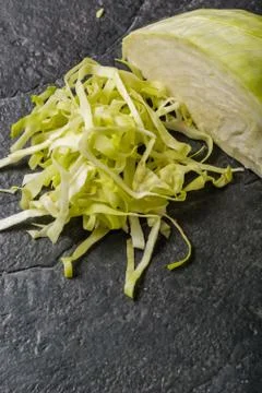 Chopped cabbage on a black stone background. Stock-Fotos