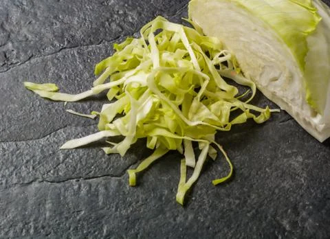 Chopped cabbage on a black stone background. Foto stock