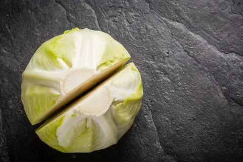 Chopped cabbage on a black stone background. Stock Photos