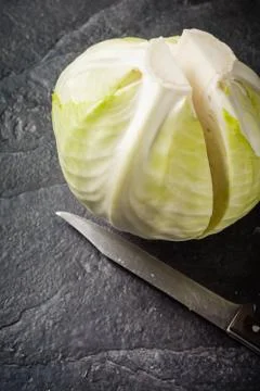 Chopped cabbage on a black stone background. Stock Photos