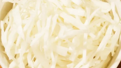 Chopped carrot and cabbage in white cup on wooden background close up. Stock Footage