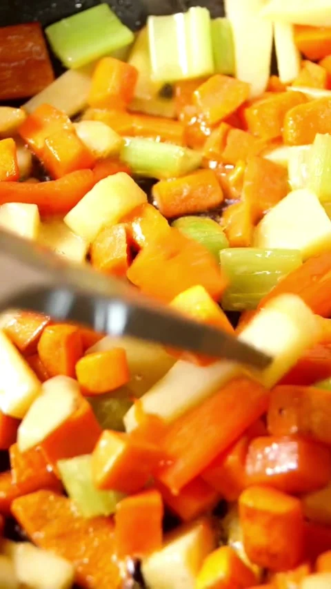 Chopped carrots and celery are being sautÃÂ©ed in oil Video stock 331991850