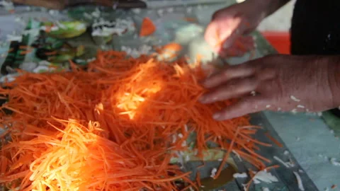 Chopped carrots in a woman's hand Vídeos de archivo 142802200