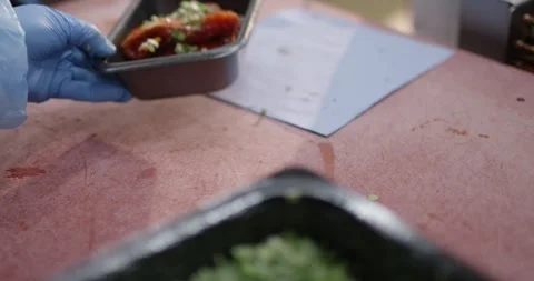 Chopped chives being sprinkled over marinated meat in a black tray with a bowl Vídeo Stock 340000100
