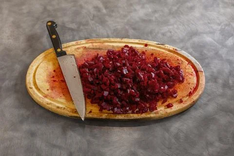 Chopped Cooked Beetroot and Kitchen Knife on Red Stained Board Stock Photos
