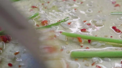 Chopped fresh garlic, red hot chilli pepper and aromatic parsley stems frying in Stock Footage 250025614