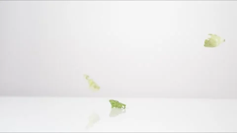 Chopped Green Leaf Lettuce Bouncing Slow Motion White Tabletop Closeup Macro Stock Footage 335006119