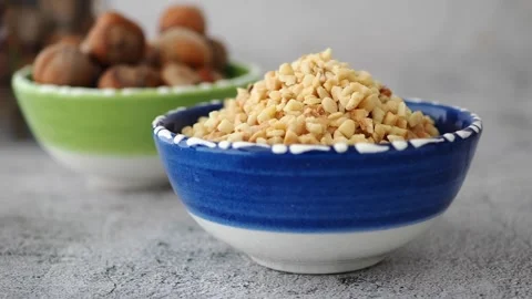 Chopped Hazelnuts in a Blue Bowl Stock Footage 344099224