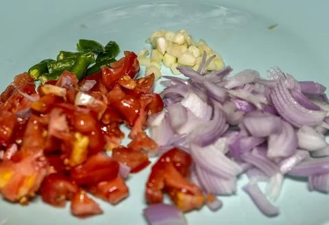 Chopped kitchen vegetables in ceramic plate at indoor Stock Photos