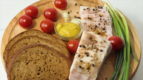 Chopped lard on a board with spices, pepper, mustard, cherry tomatoes, garlic Stock Footage 194674792