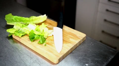 Chopped Lettuce on Cutting Board with White Ceramic Knife 60 fps Stock Footage 59785850