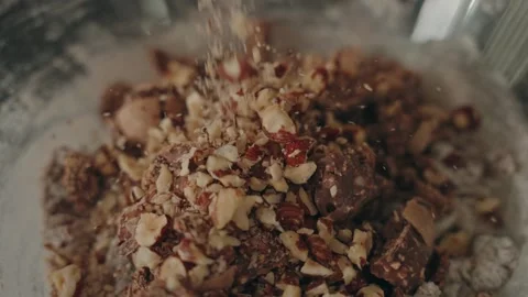 Chopped nuts falling onto chocolate mixture close up Stock-Footage 330992709