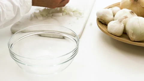 Chopped onion. Chef puts chopped white onion off cutting board into a glass bowl Video stock 131771407