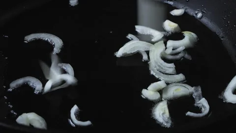 The chopped onion falls into a frying pan with heated oil. Medium plan 库存影片 271377448