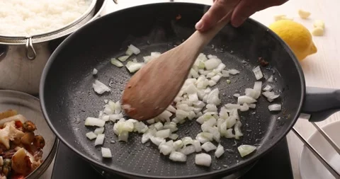 Chopped onion is stirred in a pan. Stock Footage 249526033