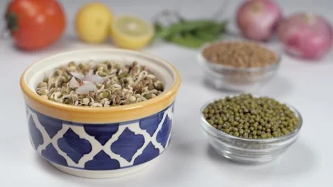 Chopped onions and tomatoes falling in a colorful bowl full of green sprouts Stock-Footage 153130786