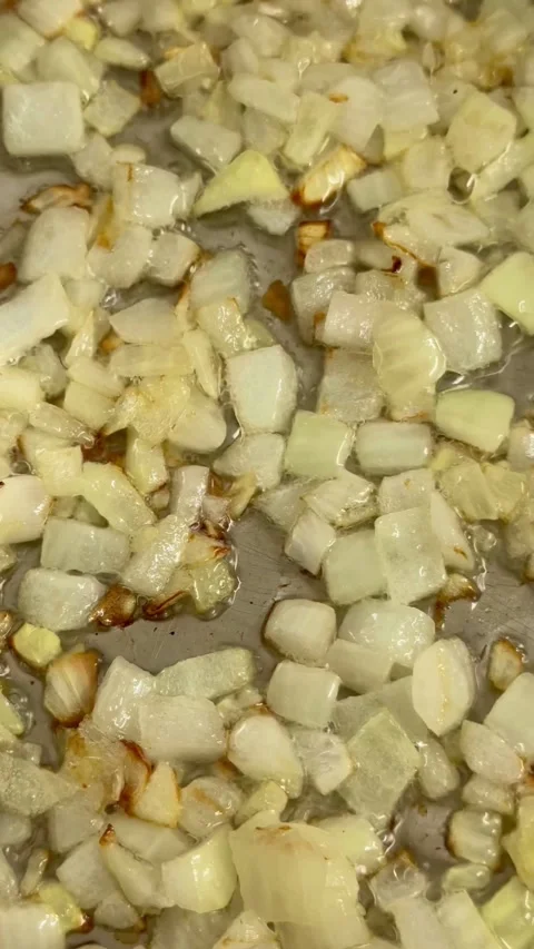 Chopped onions are being fried in a hot pan 스톡 동영상 334593494