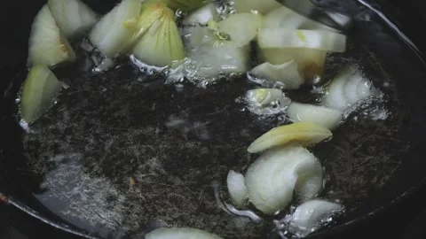 Chopped onions fall into a frying pan with boiling oil and fry. Close-up. Stock Footage 300028640