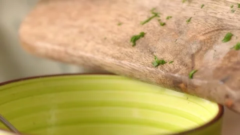 Chopped parsley falls from a cutting board into bowl. Stock Footage 258651284