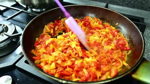 Chopped peppers, tomatoes, onions and grated carrots sizzle in a pan as they fr Video stock 292014181