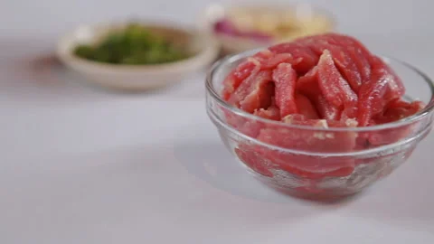 Chopped pieces of raw beef on a white table. Ingredients stuff background Video stock 130400957