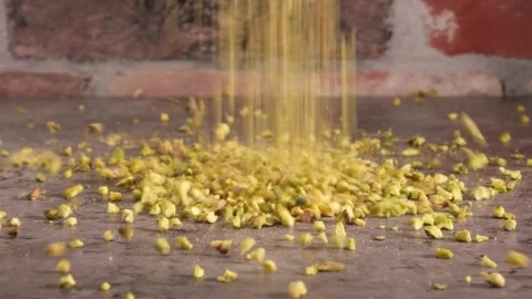 Chopped Pistachio Nuts Falling onto table - 4K Slow Motion Extreme Close Up Stock Footage 334780989