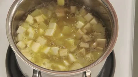 Chopped ramsons being added to simmering stock with diced vegetables Stock Footage 24657926
