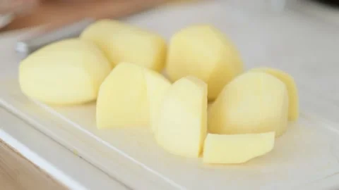 Chopped raw potatoes on cutting board, cooking vegetables dinner in kitchen. Stock-Footage 229558532