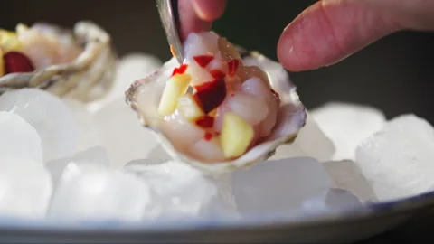 Chopped scallops pineapple and red pepper placed into oyster shell by chef Stock Footage 274674835