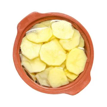Chopped slices of potatoes in ceramic ware for cooking 库存照片