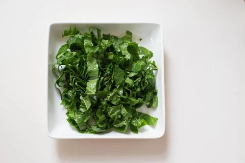 Chopped spinach in a white dish Stock Photos
