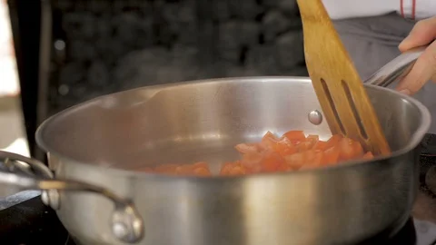 Chopped tomato frying in pan Stock Footage 107899889