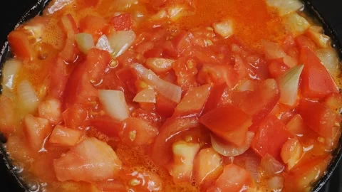 Chopped tomatoes and sweet pepper and onion are fried in a frying pan Stock Footage 303439088