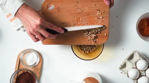 Chopped walnuts on bamboo cutting board. Finely chopped walnuts, the chef tr Stock Footage 247364058
