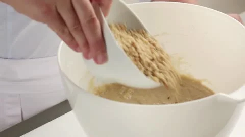 Chopped walnuts being folded into banana bread dough Stock Footage 24672414