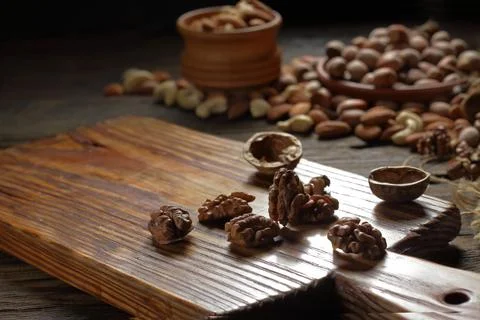Chopped walnuts on a kitchen board nuts on wooden background Stock Photos