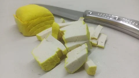 Chopped Yellow Tofu Blocks with Kitchen Knife Stock Footage 334130727