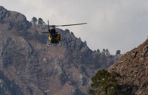 A Chopper flying from between mountain valley in rescue operation concept. Foto stock