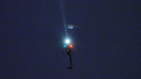 Chopper Hovering in the sky with powerful spot light - 24fps 1080p Stock Footage 91562163