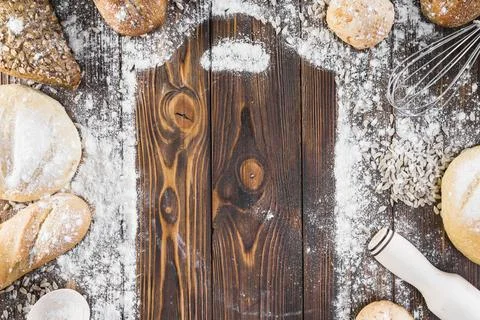 Chopping board frame with spread flour surrounded bread loaves 스톡 사진