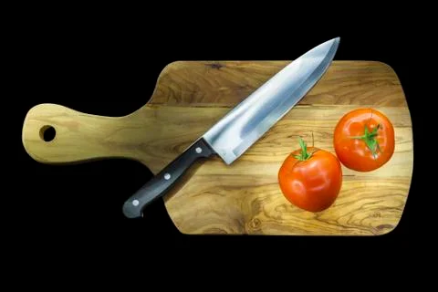 Chopping board with two tomatoes Stock Photos