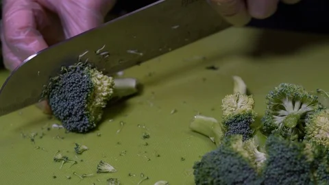 Chopping broccoli with into smaller pieces to prepare for cooking Stock Footage 111329782