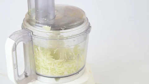 Chopping cabbage in a food processor on white Stock Footage 82614730
